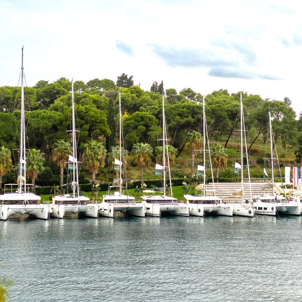 Flotte de catamarans à voile Dream Yacht amarrés le long d’un quai.
