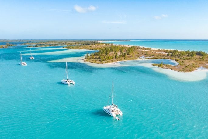 Vue d’une ligne d’îles avec trois catamarans Dream Yacht sur des eaux bleues