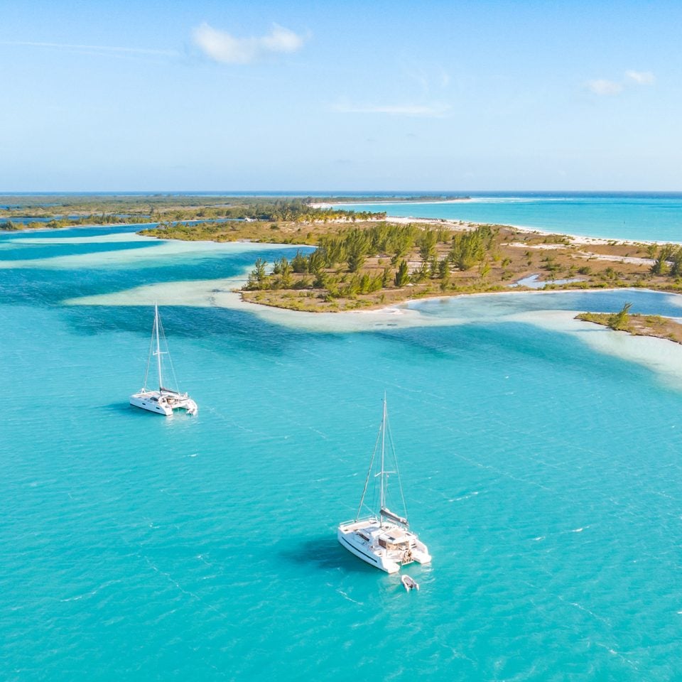 Vue d’une ligne d’îles avec trois catamarans Dream Yacht sur des eaux bleues
