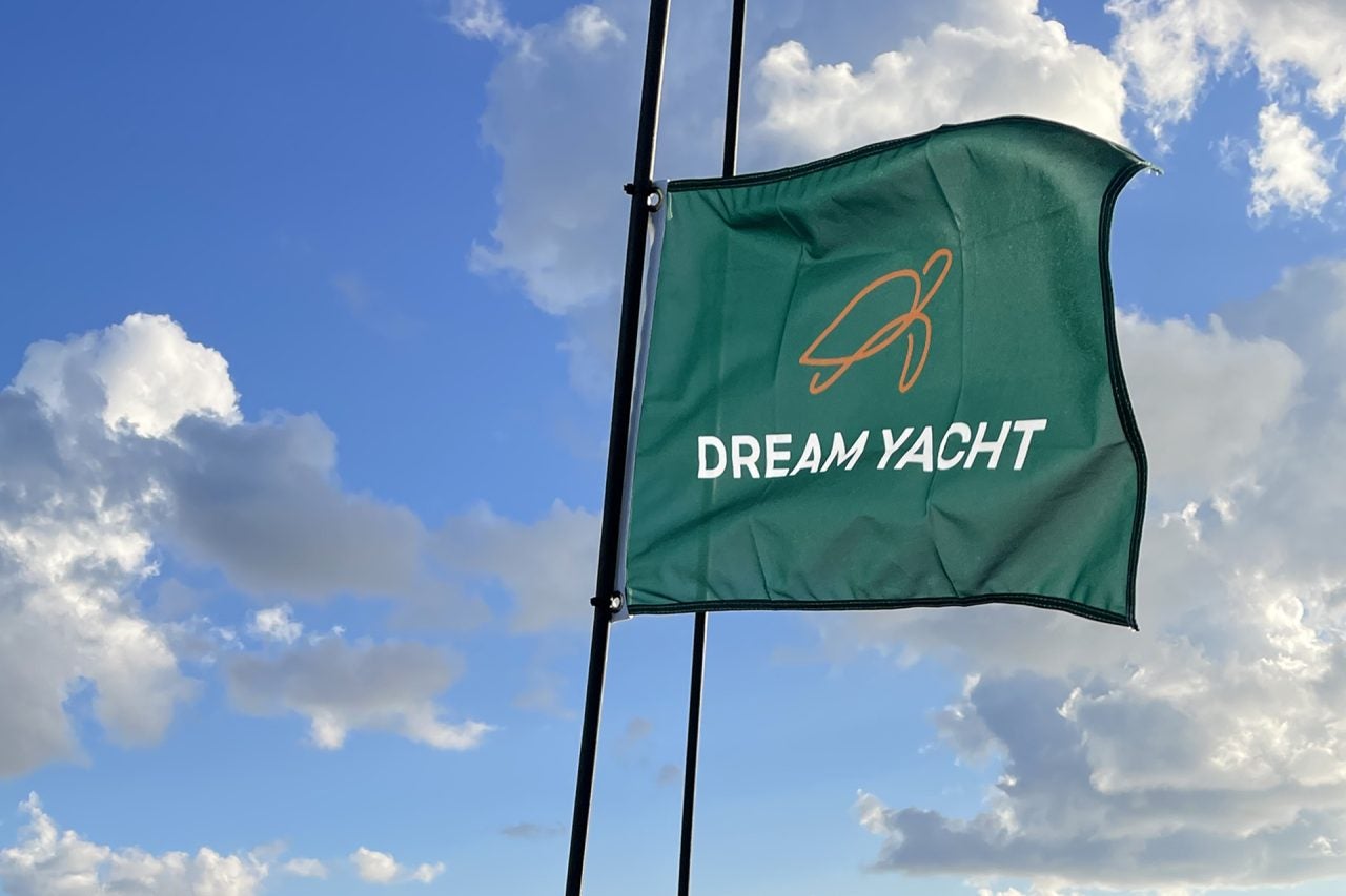 Drapeau de la marque Dream Yacht flottant sur un ciel bleu.