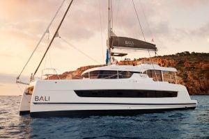 Catamaran à moteur Bali Catspace naviguant avec homme à la barre