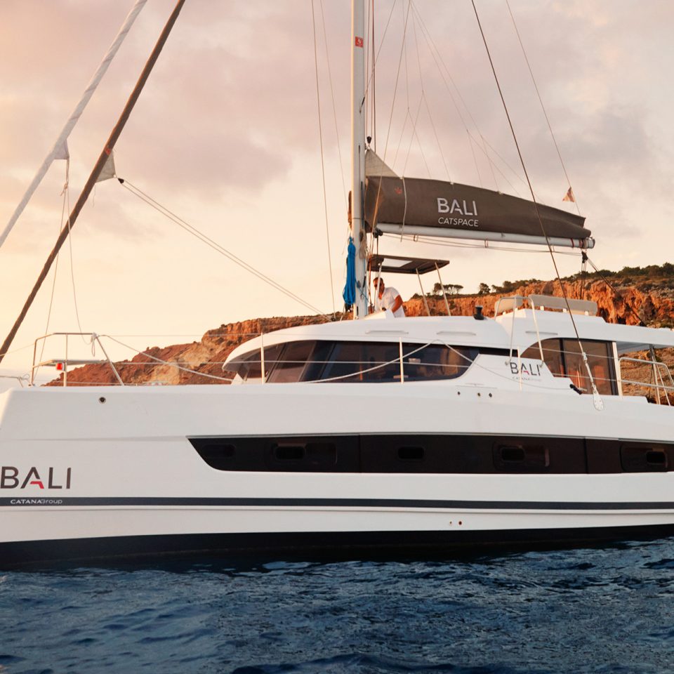 Catamaran à moteur Bali Catspace naviguant avec homme à la barre