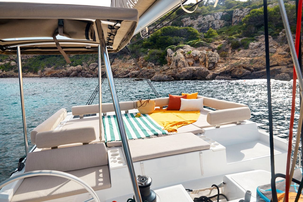 Flybridge du bateau Bali Catspace avec chaises longues et vue sur le rivage et la mer bleue