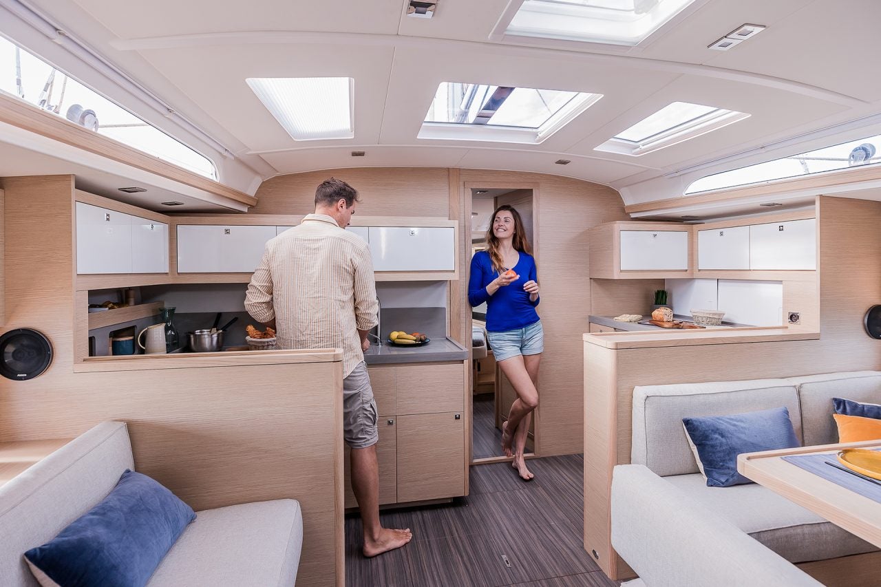 Couple utilisant la cuisine du monocoque Dufour 470