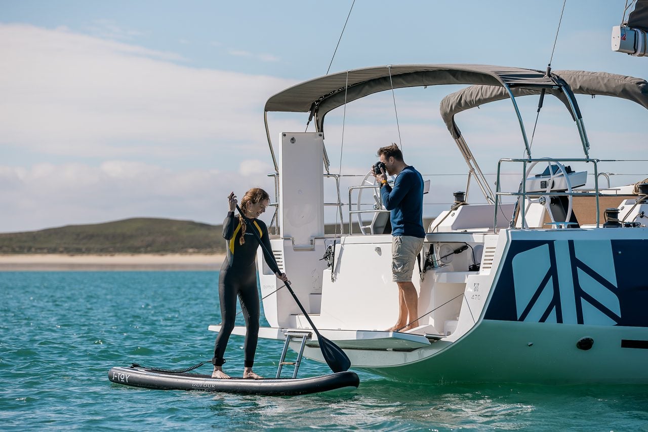 Couple utilisant la plateforme de bain du monocoque à voile Dufour 470 pour les sports nautiques