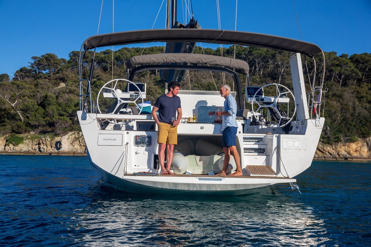 Hommes utilisant le barbecue d’extérieur sur le monocoque Dufour 61