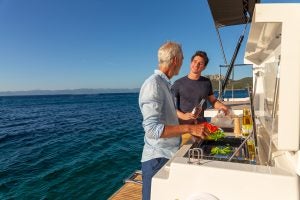Hommes utilisant le barbecue d’extérieur sur le bateau de luxe Dufour 61