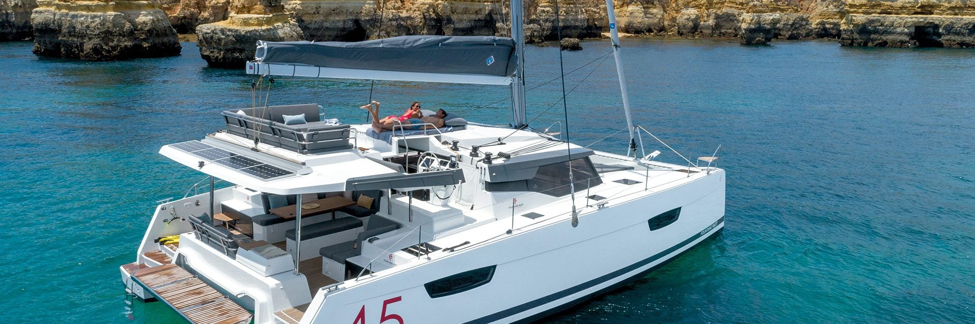 Catamaran à voile Fountaine Pajot Elba 45 au mouillage près des falaises