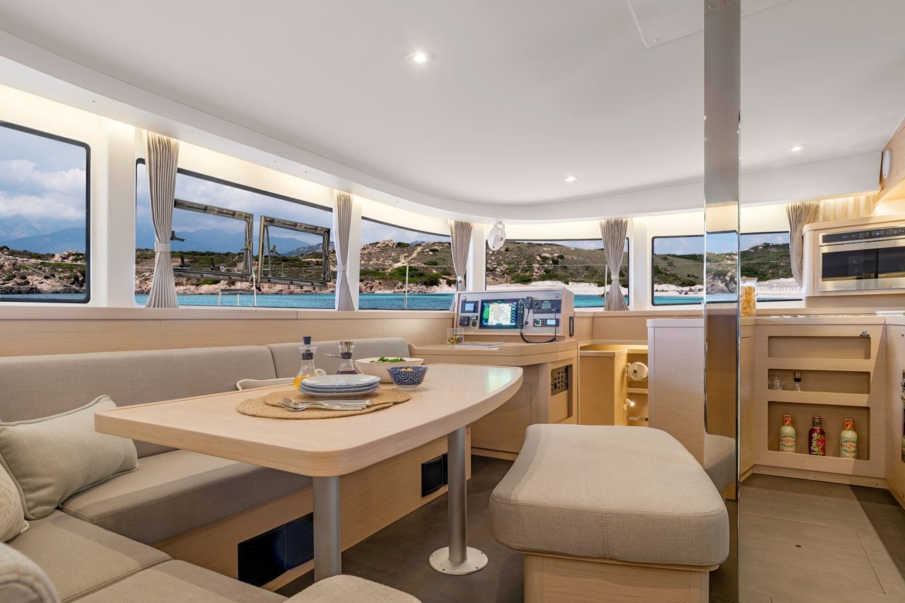 Espace de séjour intérieur avec grandes fenêtres du catamaran Lagoon 42