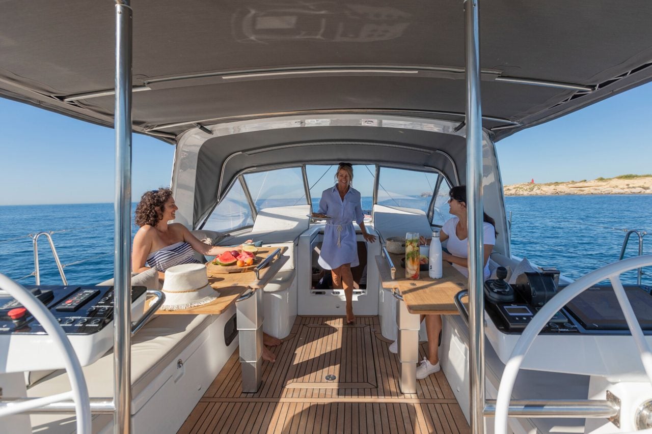 Personnes dînant à la table du cockpit du monocoque de luxe Beneteau Yacht 54