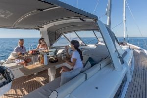Personnes dînant à la table du cockpit du monocoque Beneteau Oceanis Yacht 54