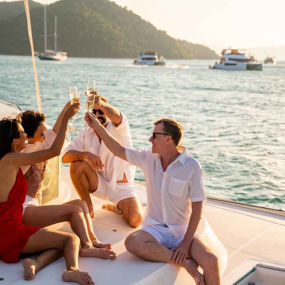 Groupe d'amis s'amusant sur un catamaran au mouillage.