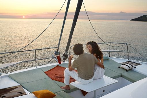 Couple on foredeck of a Bali yacht at sunset