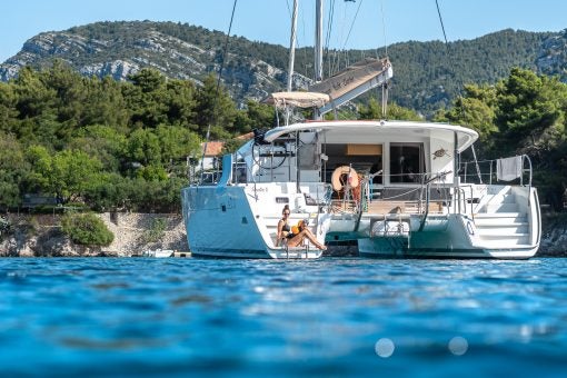 Woman on stern of a Dream Yacht catamaran