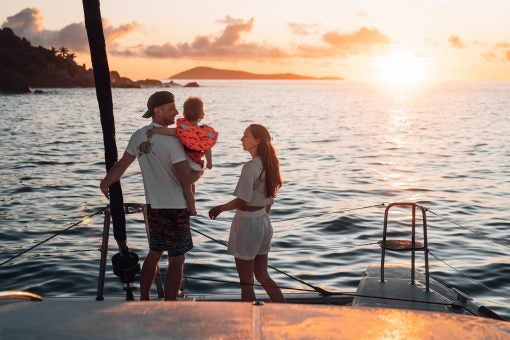 Couple and child on boat sailing the world