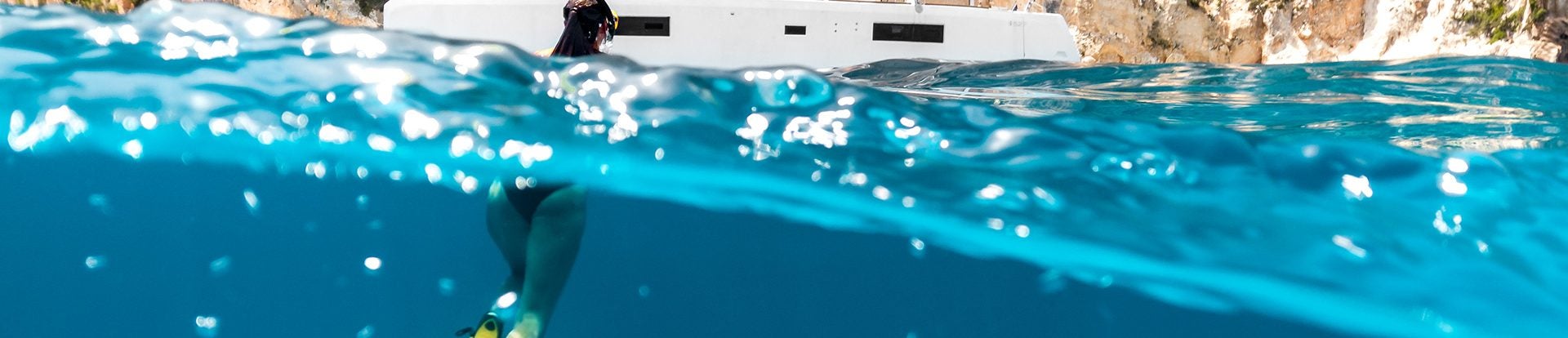 Snorkeler exploring the ocean next to his catamaran