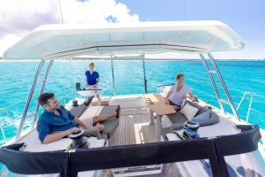 Three people in the aft cockpit onboard the Dufour 48 under sail