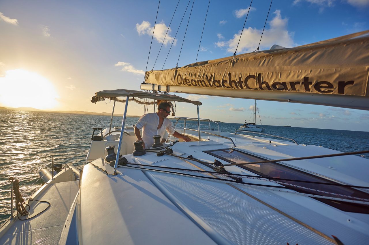 A man at the helm of a sailing yacht